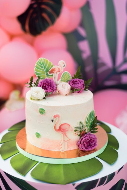 Gateau Rose Avec Des Flamants Roses Pour Les Vacances Gateau Avec Une Variete De Decorations De Feuilles De Palmier Et De Fleurs Fraiches Photo Premium