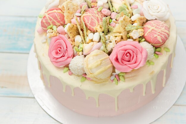 Gateau Rose Avec Des Fleurs Et Des Petits Gateaux Sur Une Plaque Blanche Photo Premium