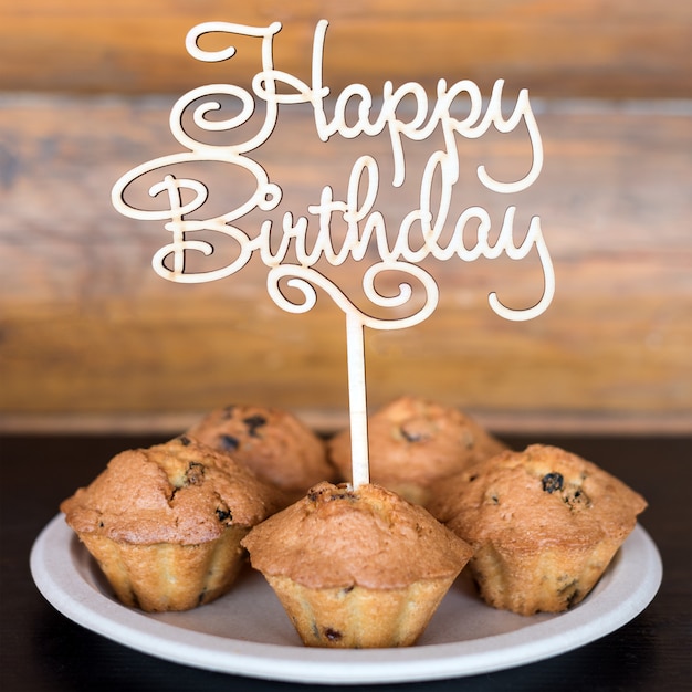 Gateaux D Anniversaire Et Muffins Avec Panneau De Voeux En Bois Sur Mur Rustique Chante En Bois Avec Des Lettres Joyeux Anniversaire Et Bonbons De Vacances Photo Premium