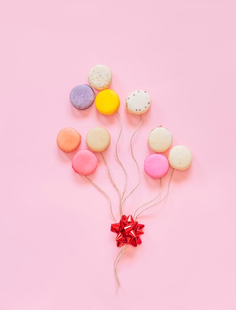 Gâteaux macarons français colorés. petits biscuits sucrés. dessert. lay plat de macarons sous forme de ballons. joyeux anniversaire et concept minimal créatif de la saint-valentin. Photo Premium