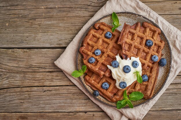 Gaufres Bananes Au Chocolat Avec Des Bleuets, Sur Une Vieille Table En Bois Sombre. Vue De Dessus, Espace De Copie Photo Premium