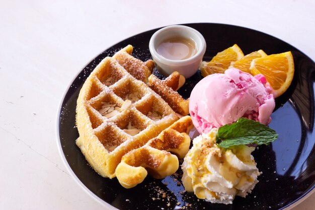 Gaufres maison servies avec de la glace à la fraise. dessert sucré. Photo Premium