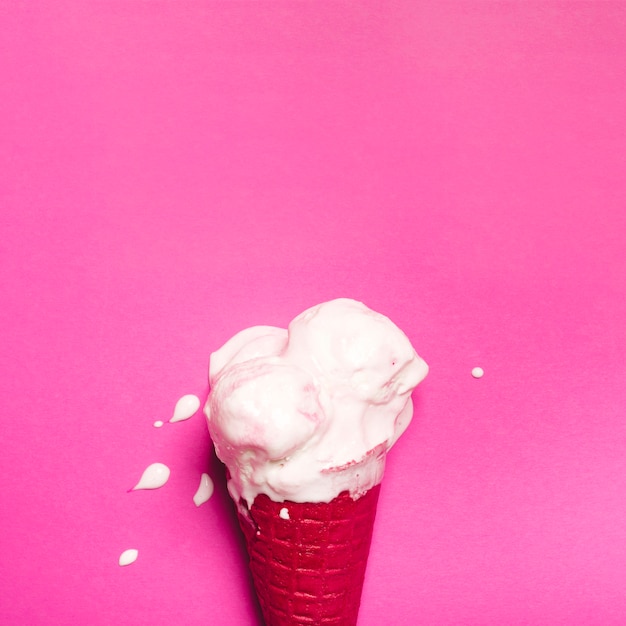 Glace fondue dégoulinant dans le cône rouge Photo gratuit