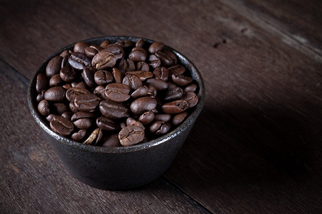 Grains de café dans un bol brun Photo Premium