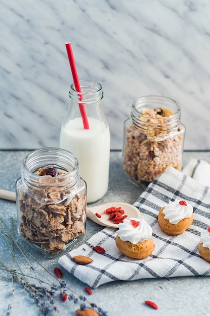 Granola Fait Maison Muesli Gateaux Muffins Fruits Secs Lait Avec Paille Rouge Et Chiffon Sur Fond De Beton Photo Gratuite