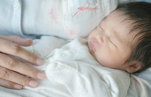 Gros Plan D Un Bebe Qui Dort Confortablement Dans Les Bras De La Mere Photo Premium