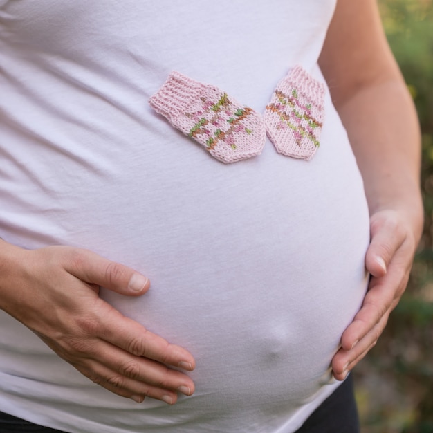 Gros Plan D Une Femme Enceinte Avec Une Paire De Mitaines Bebe Mignon Sur Son Ventre Photo Gratuite