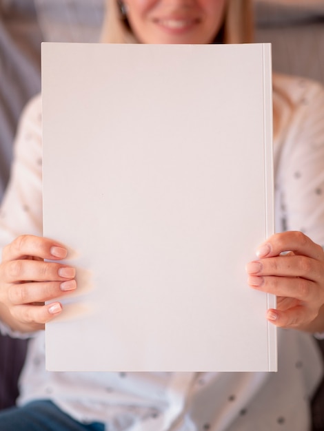 Gros plan d'un magazine-maquette tenu par une femme Photo gratuit