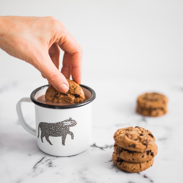 Gros plan, de, main, trempettes, biscuit, dans, tasse café Photo gratuit