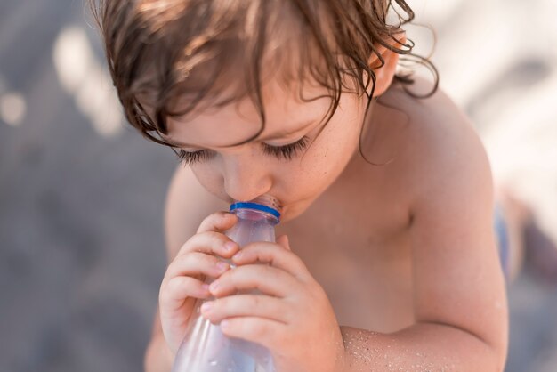 Gros Plan D Un Petit Enfant Qui Boit De L Eau Photo Premium