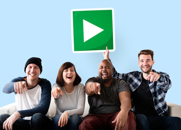 Groupe d'amis heureux tenant un bouton de lecture Photo gratuit