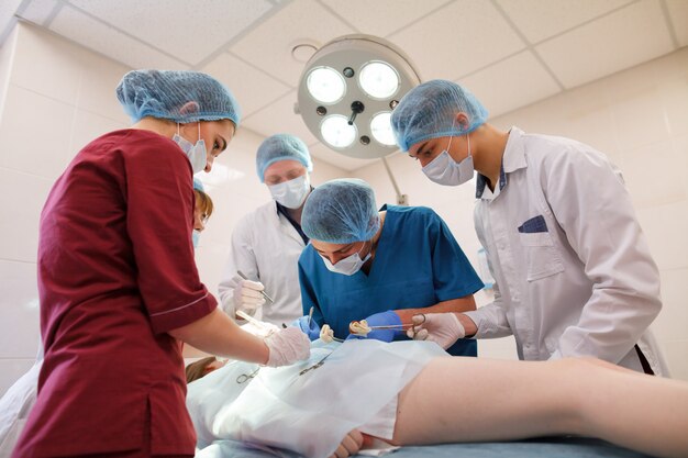 Un groupe de chirurgiens opérant dans un hôpital. Photo Premium