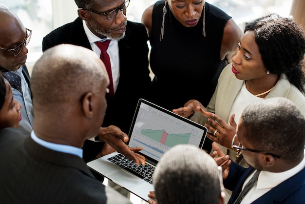 Un groupe de gens d'affaires internationaux discutant avec un ordinateur portable Photo Premium