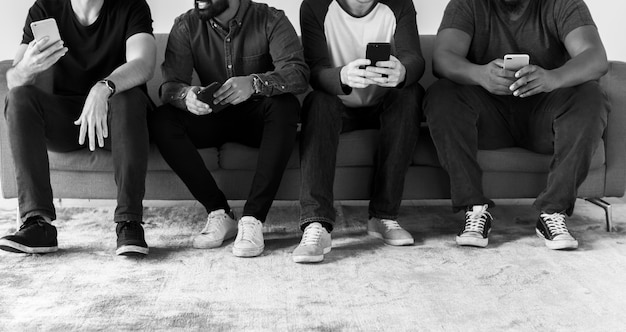 Groupe d'hommes divers utilisant le concept de médias sociaux et internet de téléphonie mobile Photo gratuit