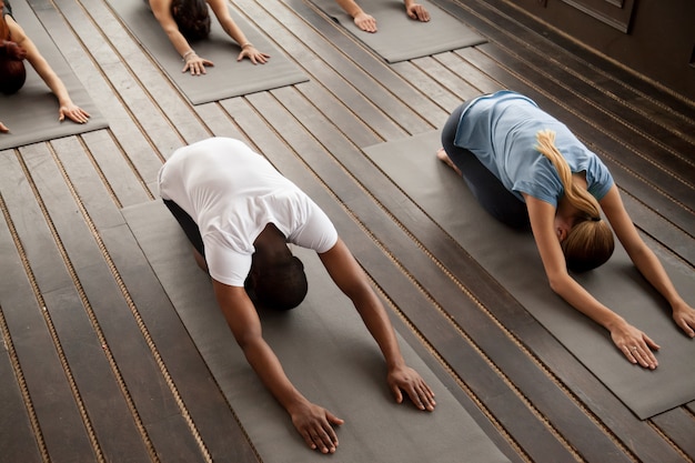 Groupe, de, jeunes, dans, balasana, pose, vue haut Photo gratuit