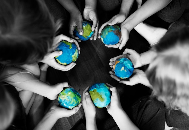 Groupe de mains diverses enfants tenant des boules de globe ensemble ensemble Photo gratuit
