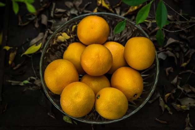 Groupe d'oranges fraîchement cueillies et section dans un panier Photo gratuit