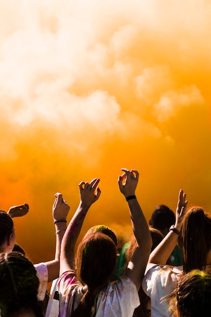 Groupe de personnes dansant devant l'explosion de poudre de holi Photo gratuit