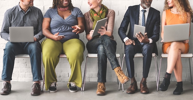 Un groupe de personnes diverses utilise des appareils numériques Photo gratuit