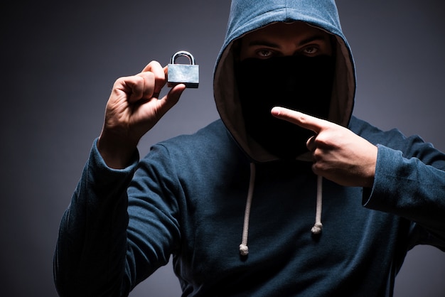 Hacker portant une cagoule dans une pièce sombre Photo Premium