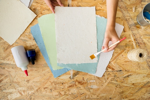 Haute vue angle, de, a, femme, main, utilisation, pinceau, sur, fait main, papiers Photo gratuit