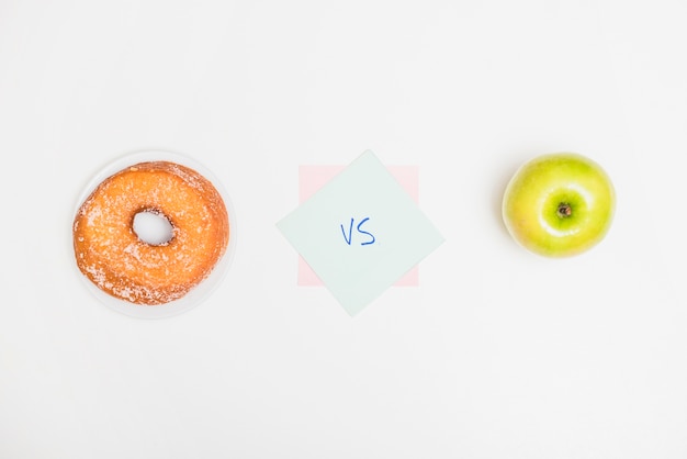 Haute vue angle, de, pomme verte, contre, beignet, sur, fond blanc Photo gratuit