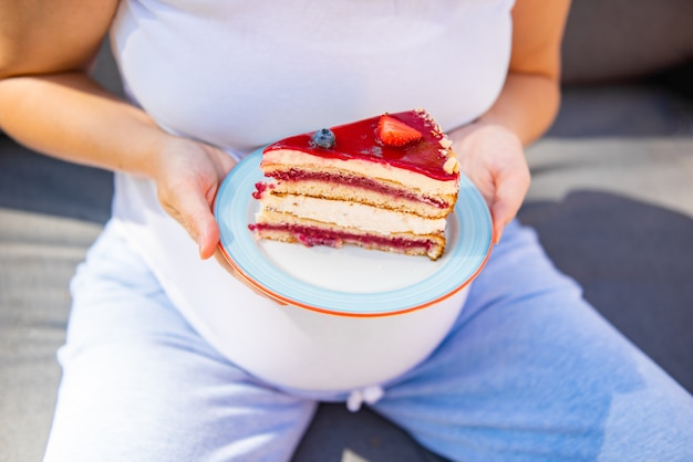 Heureuse Femme Enceinte Manger Un Gateau Sucre Dans Le Parc D Ete Photo Premium