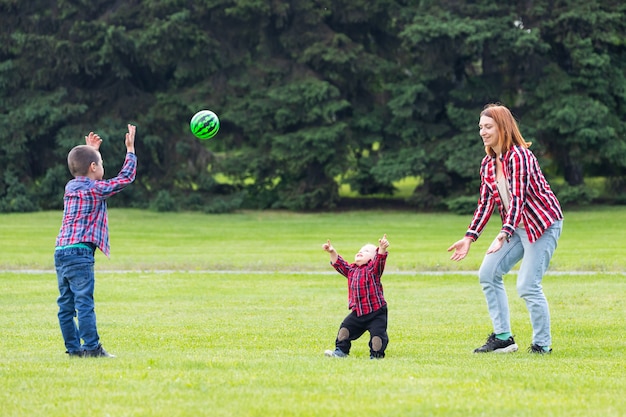 Heureuse Jeune Maman Joue Avec Le Ballon Avec Son Bebe Dans Un Parc Sur Une Pelouse Verte Photo Premium