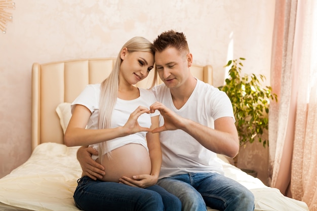Heureux Couple En Attente D Un Bebe Mains De Femme Enceinte Et Son Mari En Forme De Coeur Photo Premium