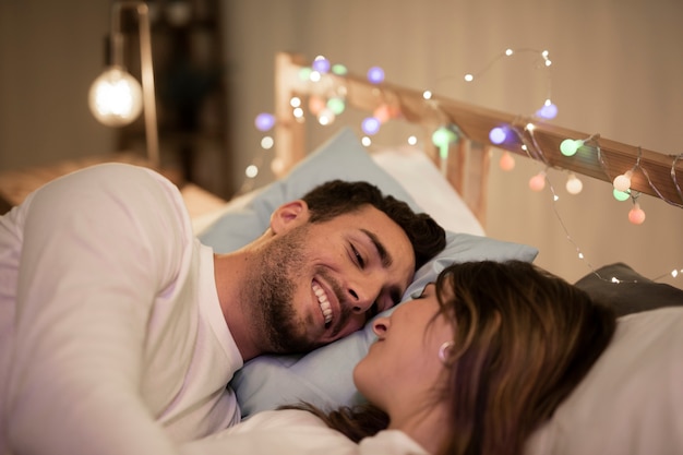 Heureux jeune couple câlins au lit | Télécharger des Photos gratuitement