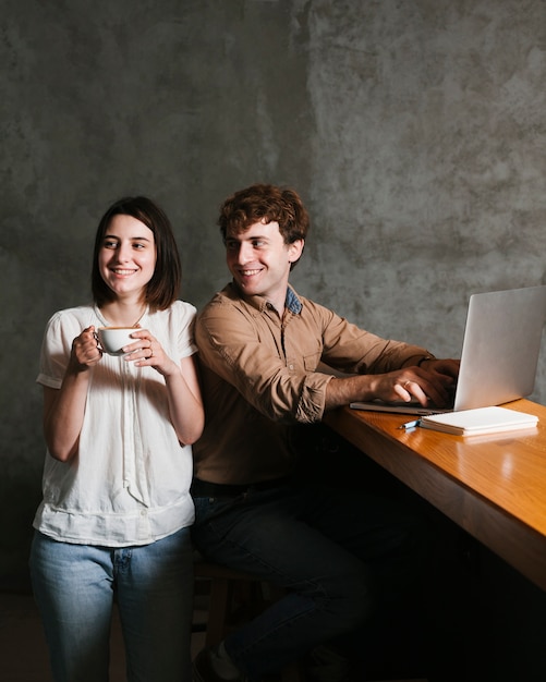 Heureux jeune couple travaillant sur un ordinateur portable Photo gratuit