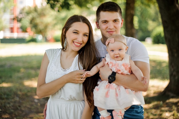 Heureux Jeune Pere Et Mere Marchant Avec Joli Bebe Fille Dans Le Parc Photo Premium