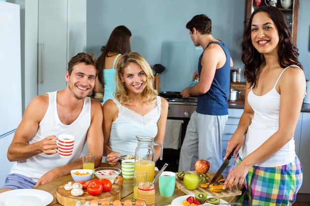 Heureux jeunes amis prépare le petit déjeuner dans la cuisine Photo Premium