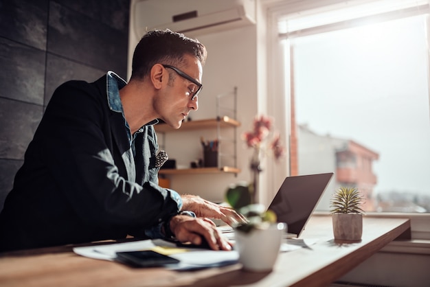 Homme D affaires Assis à Son Bureau Et Utilisant Un Ordinateur Portable