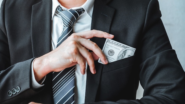 Homme d'affaires avec billets d'un dollar en poche Photo Premium