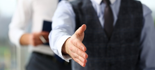 Homme en costume-cravate donne la main comme bonjour au bureau Photo Premium