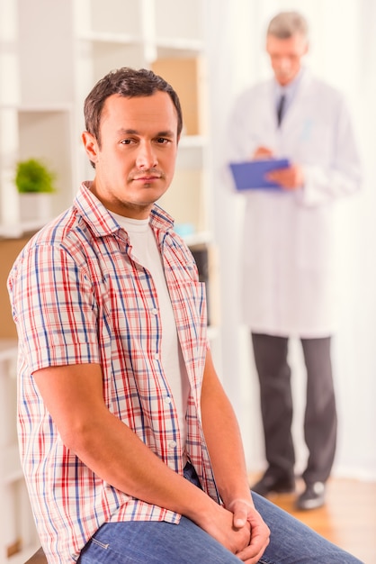 Un homme est assis dans une clinique et regarde à l'avant. Photo Premium