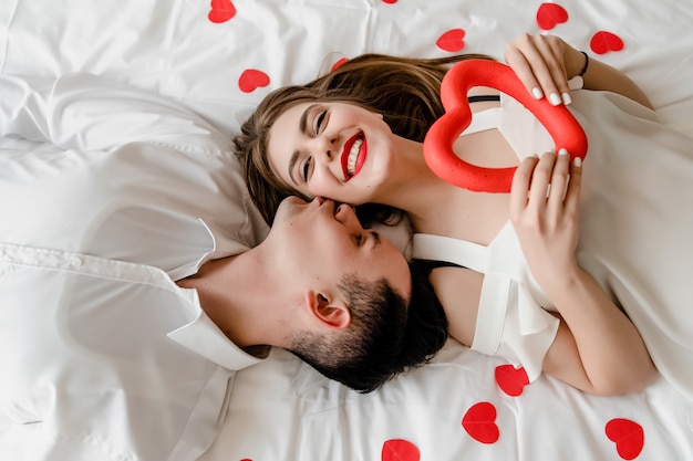 Homme Et Femme Amoureux Au Lit Avec Des Confettis En Forme De Coeur Photo Premium