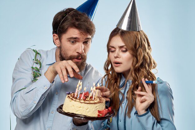 Un Homme Et Une Femme Pour Un Anniversaire Avec Un Petit Gateau Et Une Bougie Dans Une Casquette Festive S Amusent Et Celebrent Les Vacances Ensemble Photo Premium