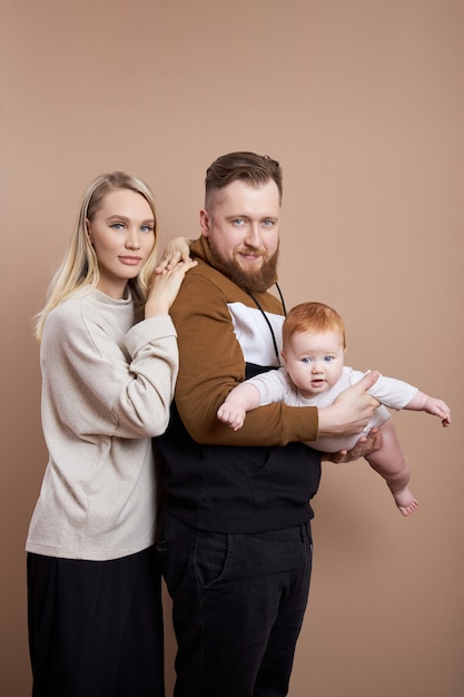 Un Homme Et Une Femme Tiennent Un Bebe Dans Leurs Bras Portrait D Un Couple Marie Apres La Naissance D Un Enfant Jeune Famille Photo Premium