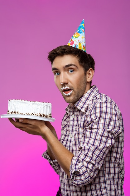 Homme Avec Un Gateau Sur Les Levres Sur Le Mur Violet Fete D Anniversaire Photo Gratuite