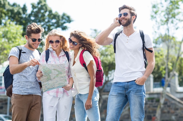 Homme de la hanche sur appel téléphonique et des amis en regardant la carte Photo Premium