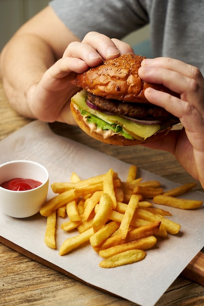 Lhomme Mange Un Hamburger Gros Plan Jeune Homme Avec Hamburger