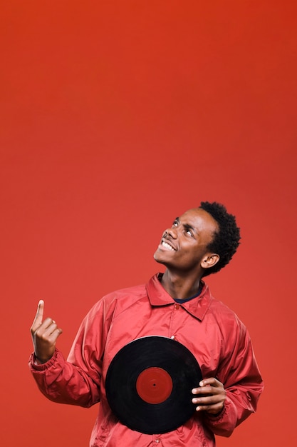 Homme noir posant avec des vinyles Photo gratuit