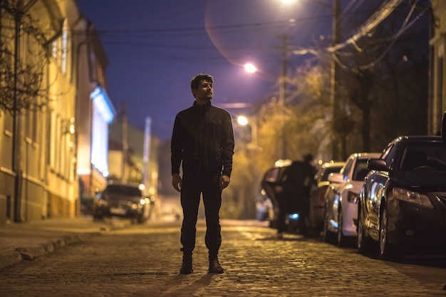 L Homme Se Tient Dans La Rue Le Soir La Nuit Prise De Vue Au