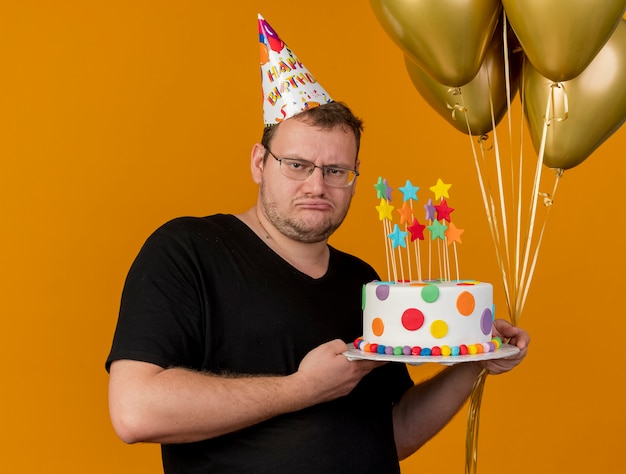 Un Homme Slave Adulte Bouleverse Dans Des Lunettes Optiques Portant Une Casquette D Anniversaire Tient Des Ballons A L Helium Et Un Gateau D Anniversaire Photo Gratuite