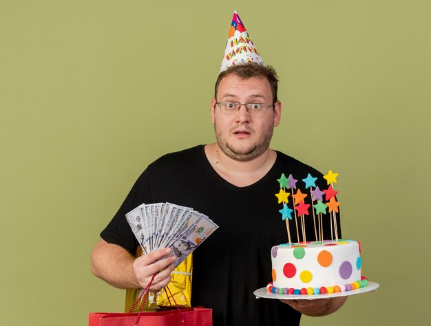 Un Homme Slave Adulte Impressionne Dans Des Lunettes Optiques Portant Une Casquette D Anniversaire Contient Une Boite Cadeau De Sac A Provisions En Papier Et Un Gateau D Anniversaire Photo Gratuite