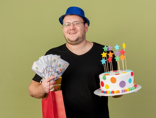 Un Homme Slave Adulte Souriant Dans Des Lunettes Optiques Portant Un Chapeau De Fete Bleu Contient Un Sac A Provisions En Papier Et Un Gateau D Anniversaire Photo Gratuite