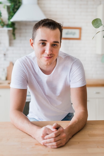 Homme Souriant En T-shirt Blanc Assis Dans La Cuisine ...