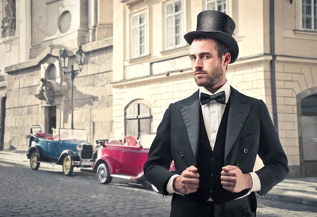 Homme de style vintage avec de vieilles voitures en arrière-plan Photo Premium